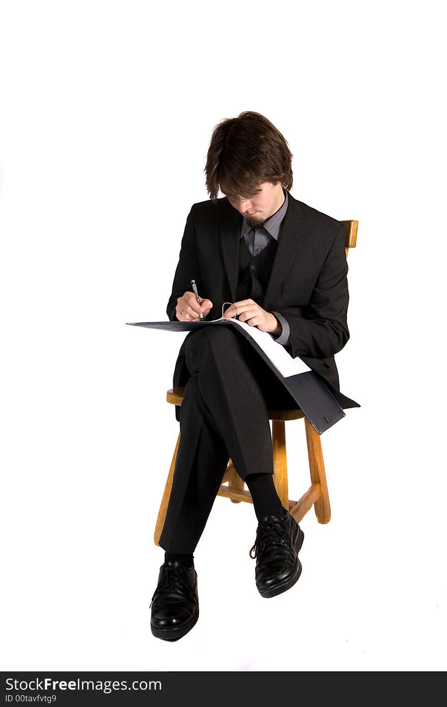 A young and pretty businessman sitting and working. A young and pretty businessman sitting and working