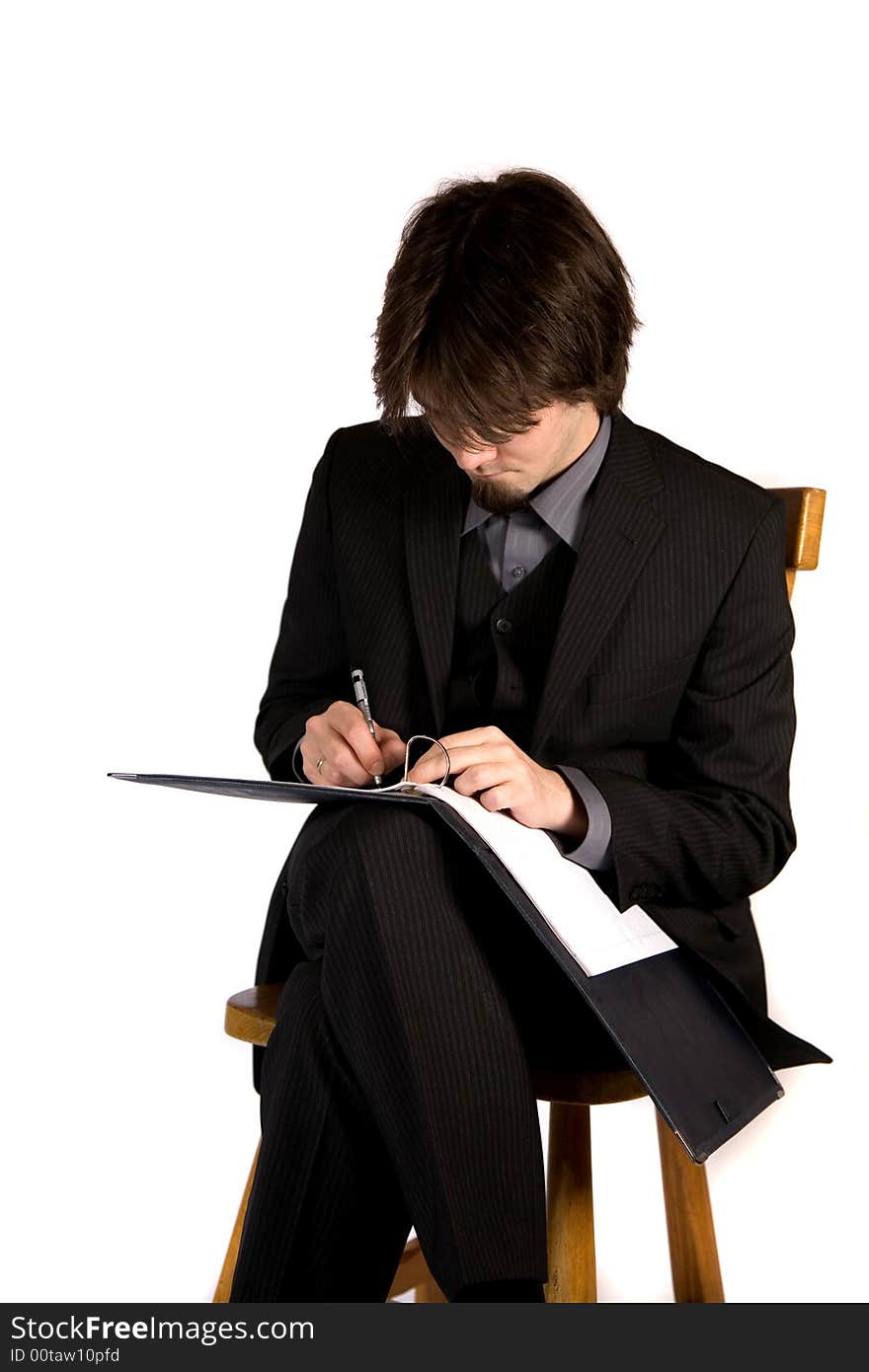 A young and pretty businessman sitting and working. A young and pretty businessman sitting and working