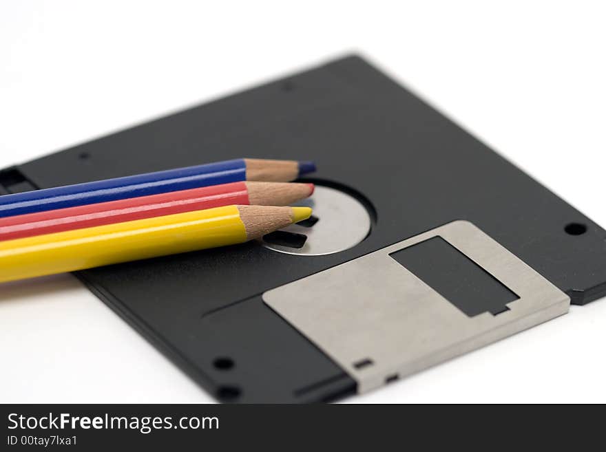 Colored pencils and a 3.5 floppy disk - examples of old technologies. Colored pencils and a 3.5 floppy disk - examples of old technologies.