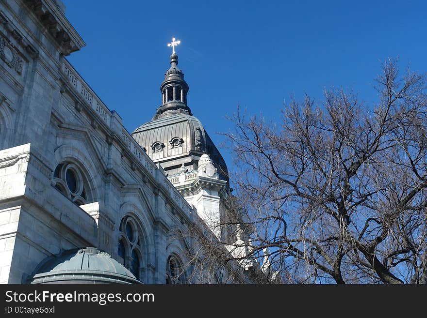 A picture of a steeple with cross reaching into sky