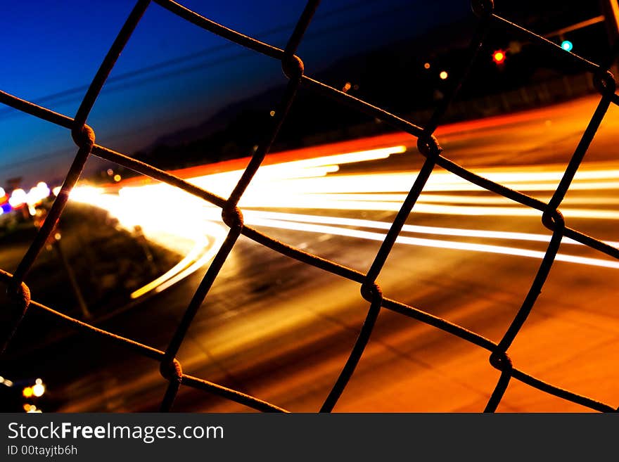 Night Traffic Behind A Fence