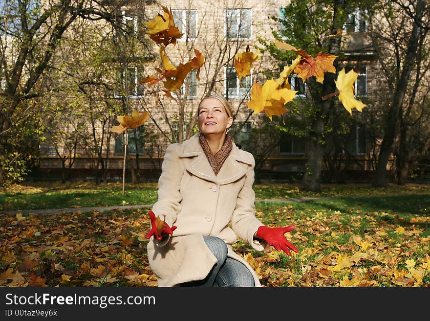 Happy woman with a throw leafs. Happy woman with a throw leafs