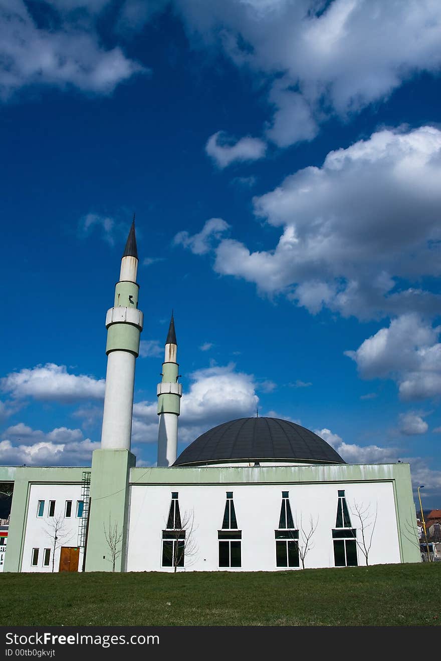 Mosque with two minarets under the blue and cloudy sky