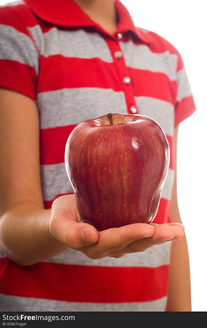 A child offering a ripe red apple in an open hand on a white background. A child offering a ripe red apple in an open hand on a white background