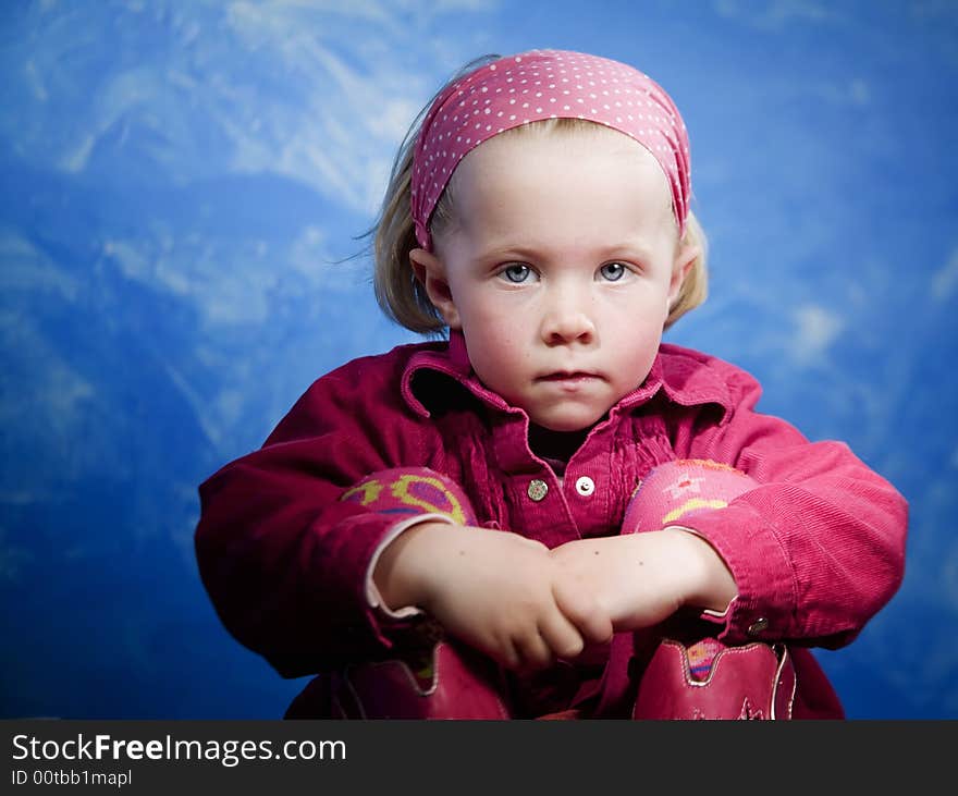 Little girl in studio in front of a blue wall. Little girl in studio in front of a blue wall