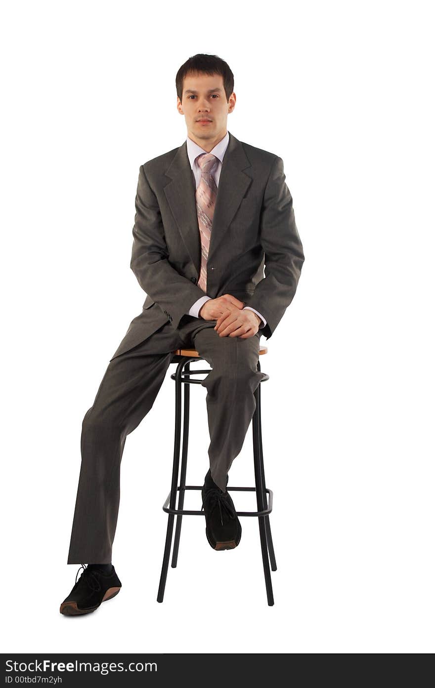 Young businessman sits on stool