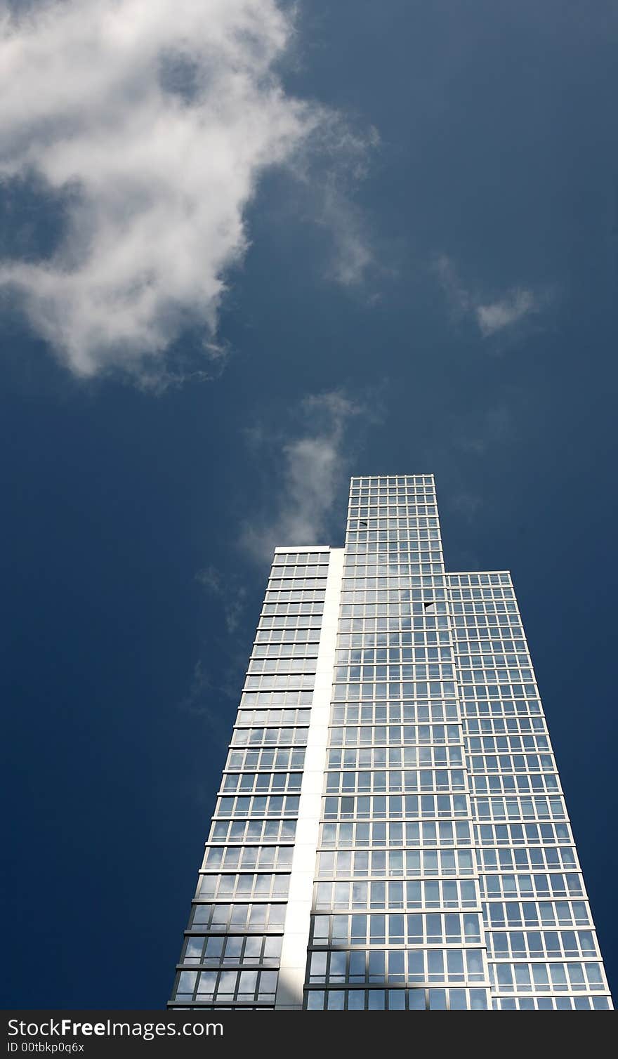 New office building against blue sky with clouds reflections in the windows, New York city