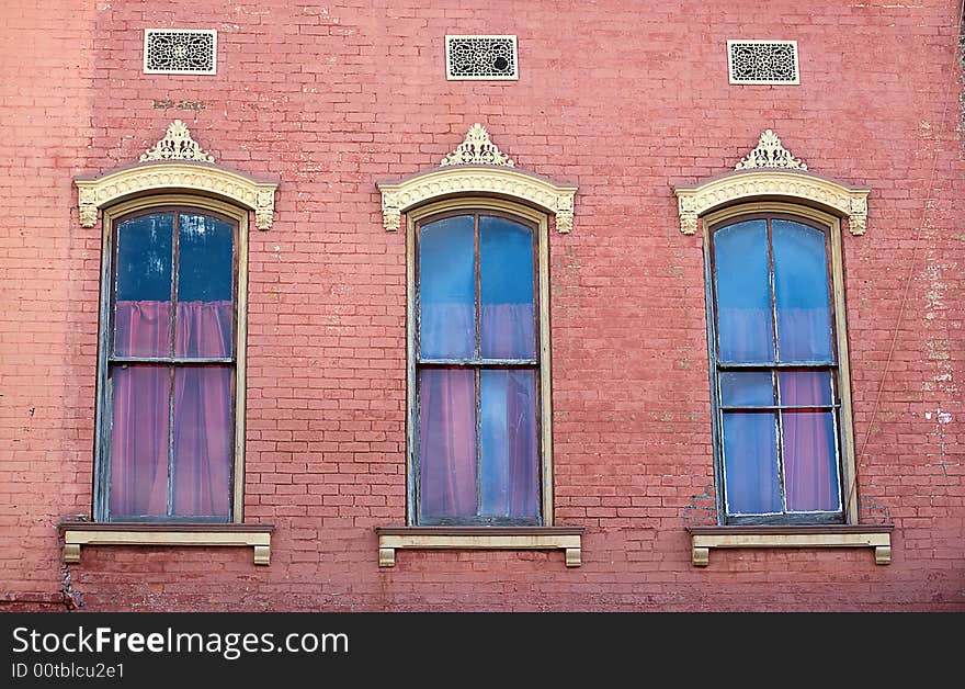 Three Windows And Pink Brick