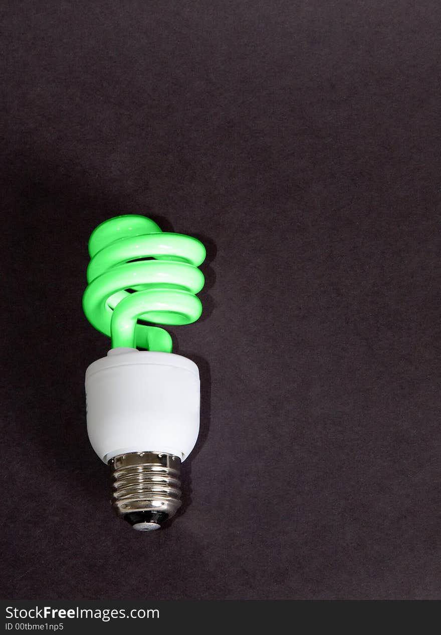 A compact florescent light bulb colored green to represent being green for our planet. A compact florescent light bulb colored green to represent being green for our planet