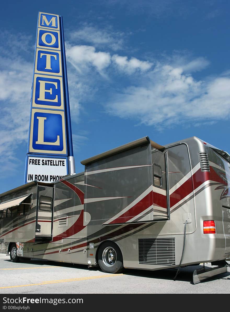 Motel sign, blue sky and tour bus