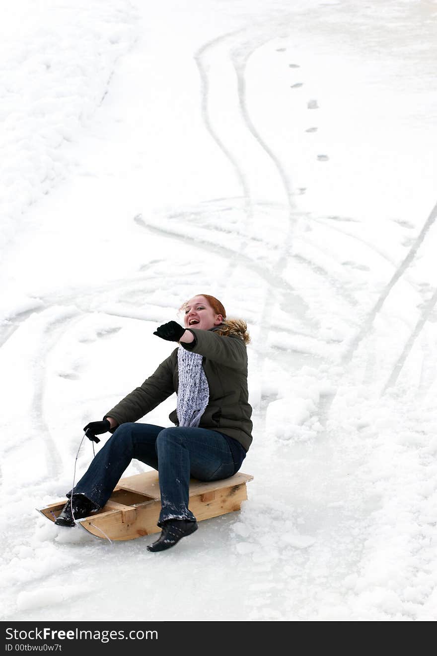 Excited woman, sliding downhill on a sledge.