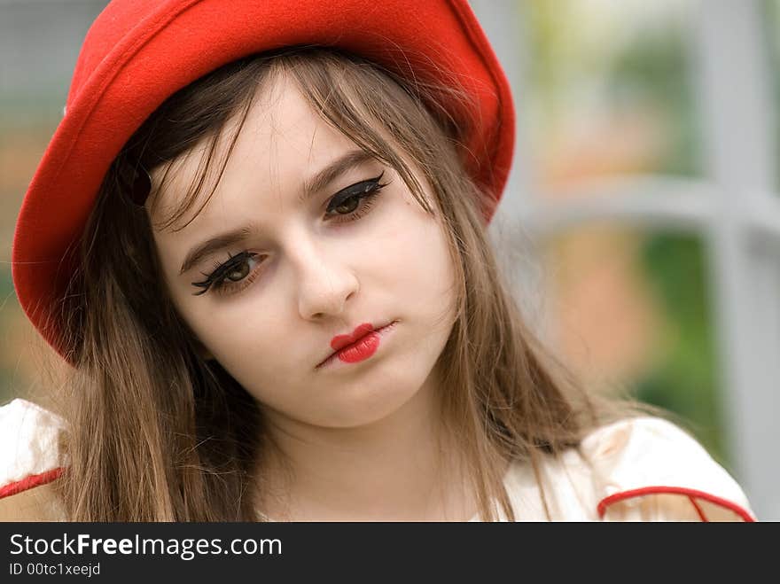 The young beautiful girl in a red cap