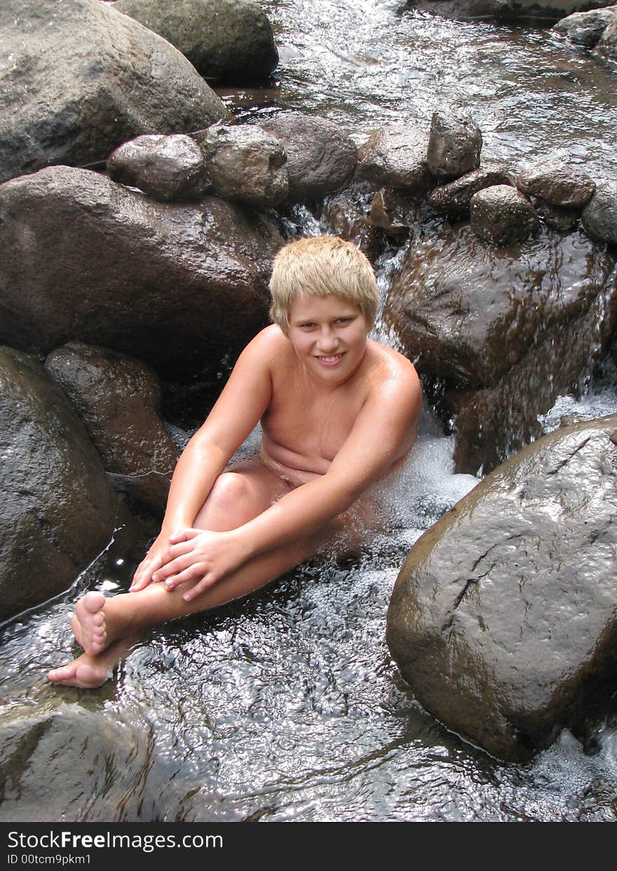 Smiling blond boy in a mountain river. Smiling blond boy in a mountain river