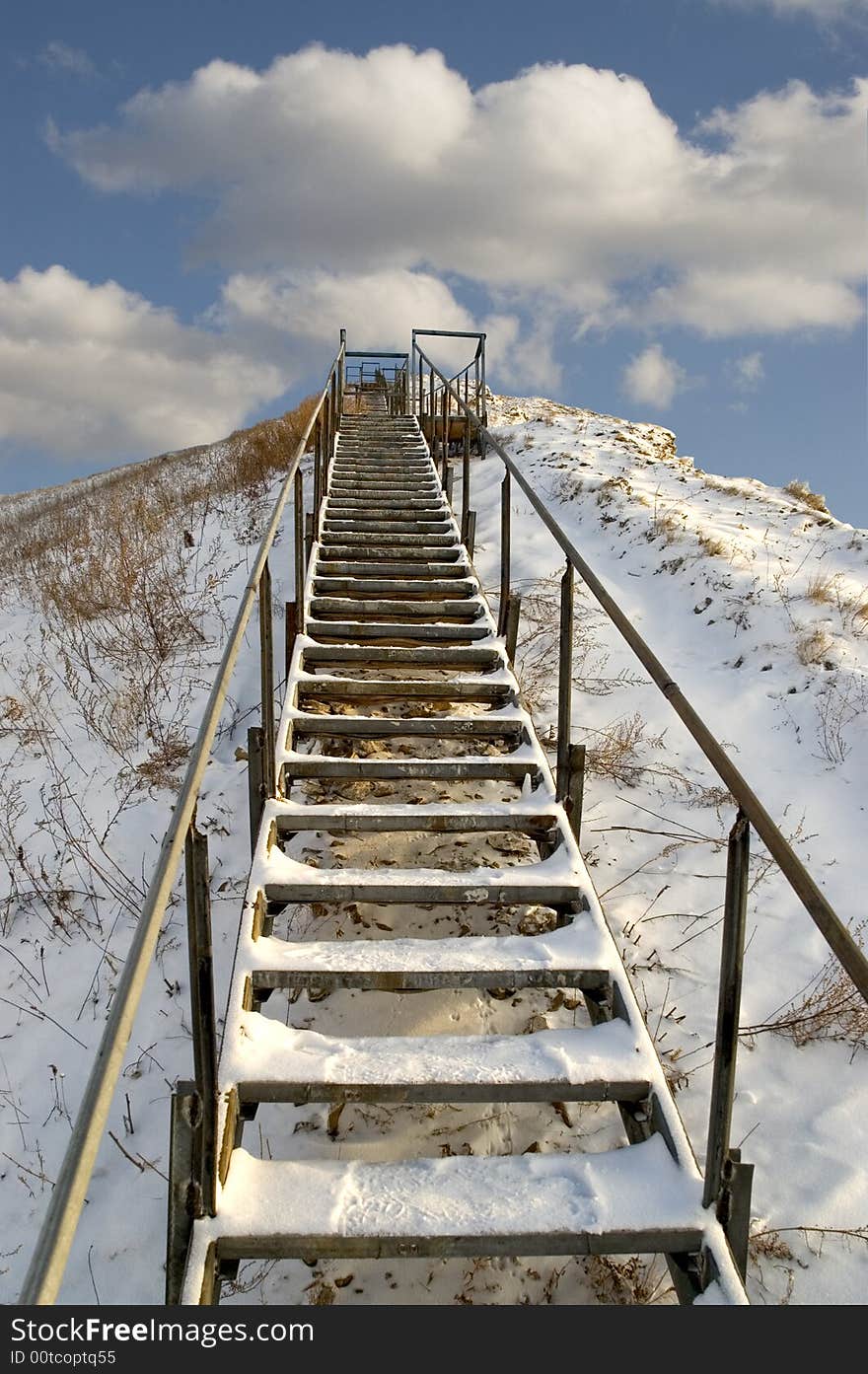 Ladder on a snow mountain on a background of the light-blue sky. Ladder on a snow mountain on a background of the light-blue sky.