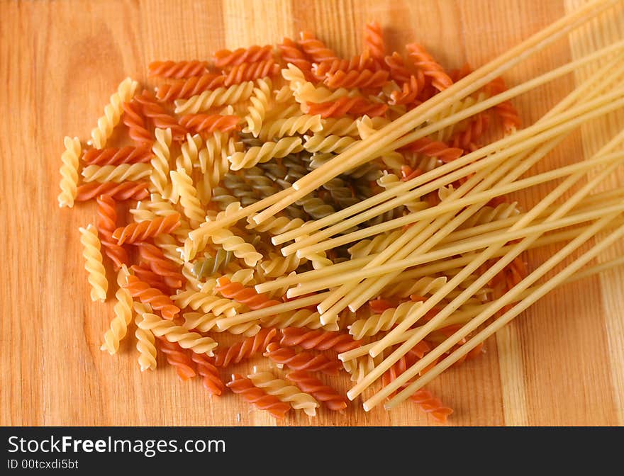 Raw colour pasta background on yellow wooden cook-table. Raw colour pasta background on yellow wooden cook-table