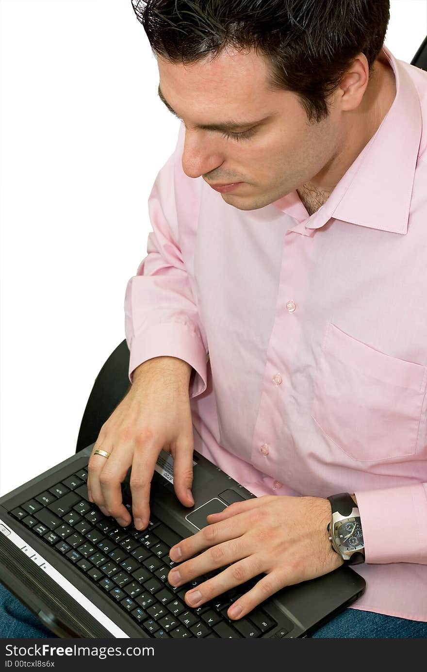 A man, sitting in his chair, holding a laptop computer on his knees, in the middle of some serious working. A man, sitting in his chair, holding a laptop computer on his knees, in the middle of some serious working