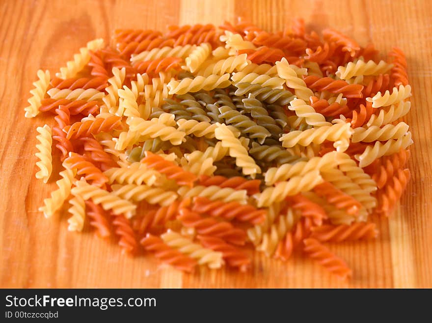 Raw colour pasta background on yellow wooden cook-table. Raw colour pasta background on yellow wooden cook-table