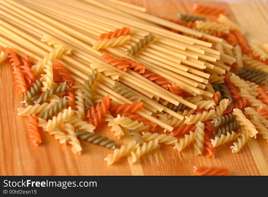 Raw colour pasta background on yellow wooden cook-table. Raw colour pasta background on yellow wooden cook-table