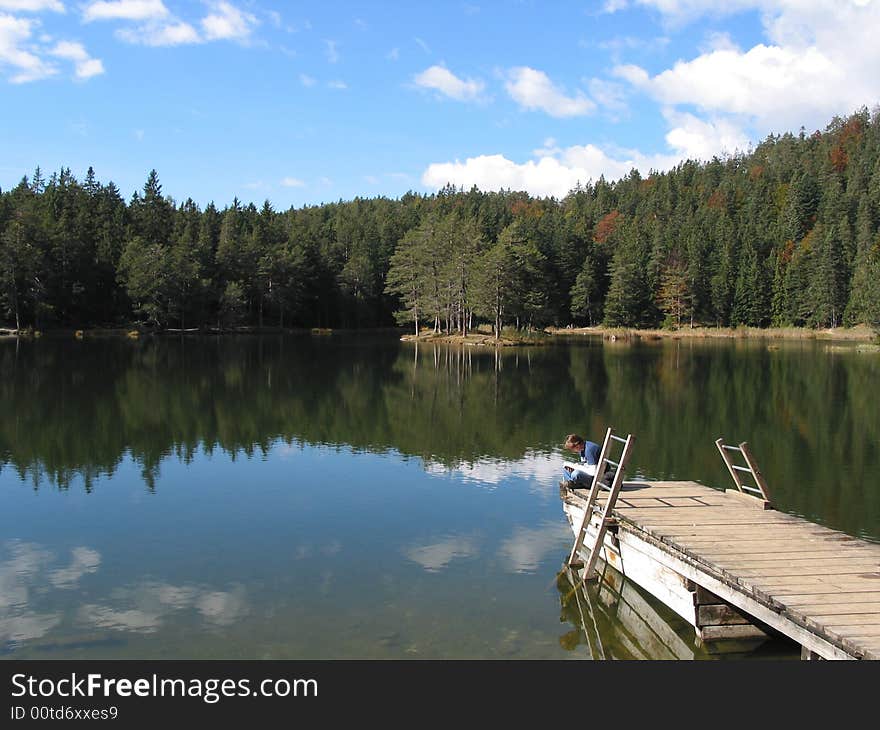 Sitting on a lake in tirol and reading a book