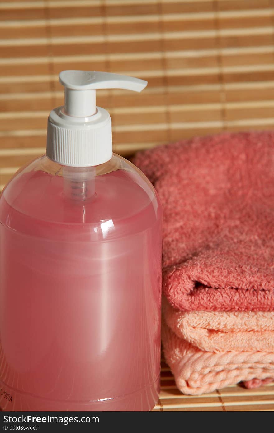 Pink container with hand pump and towels. Pink container with hand pump and towels