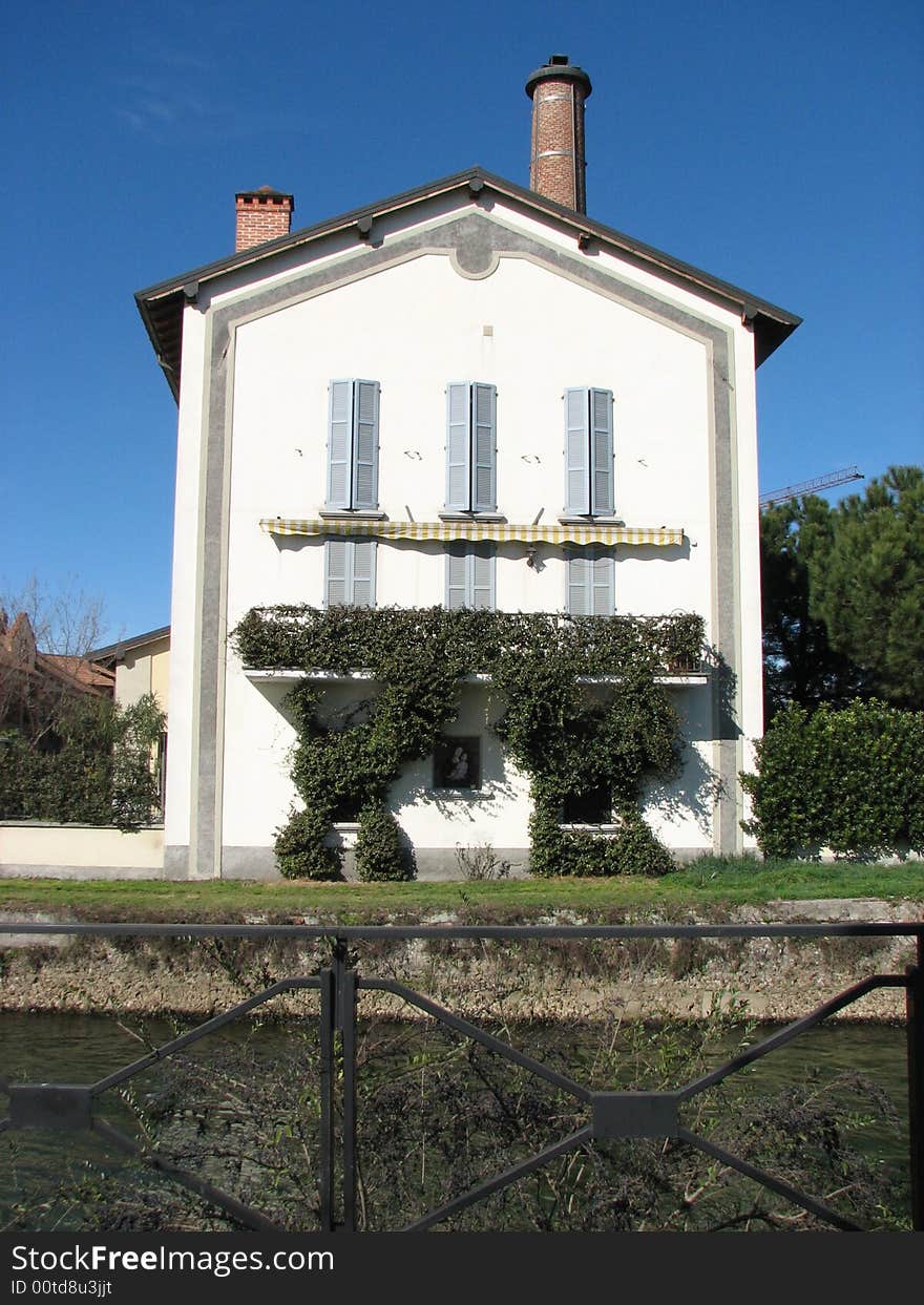 View of a 19th century factory converted into a house on a channel called Naviglio Martesana near Milan. View of a 19th century factory converted into a house on a channel called Naviglio Martesana near Milan.