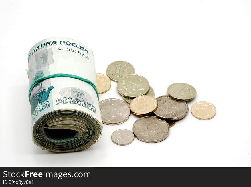 The banknotes braided in a roll and coins on a white background