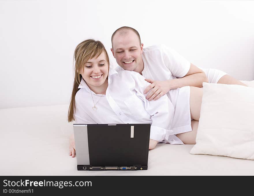 Smiling couple with laptop on a couch. Relax at home. Smiling couple with laptop on a couch. Relax at home.