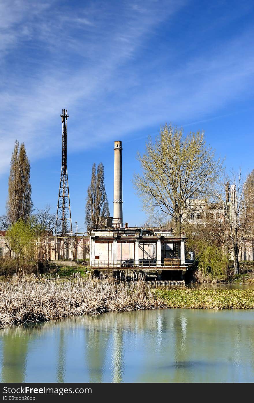 A view with a industrial facility and water reflection