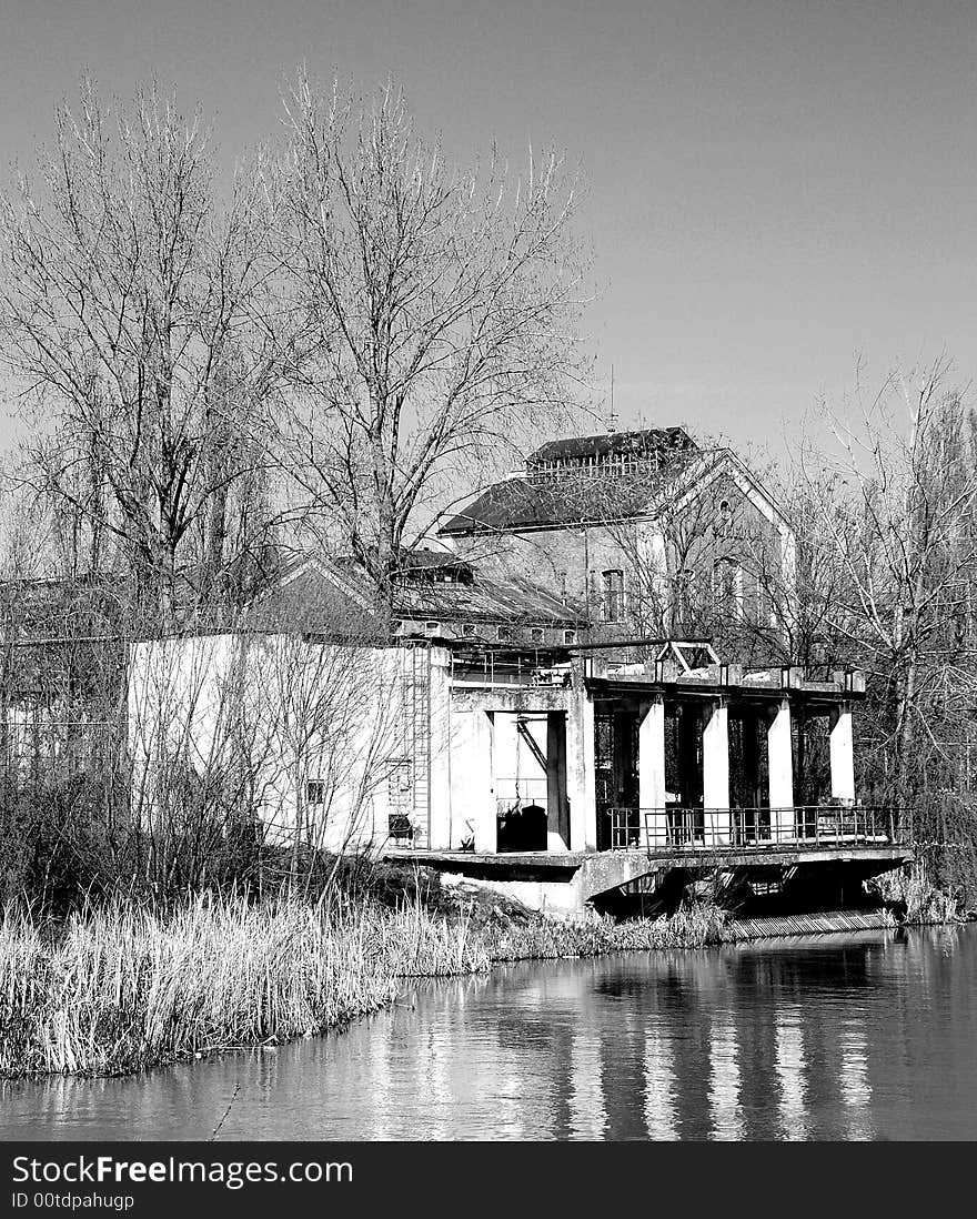 A view with an abandoned industrial facility and water reflection