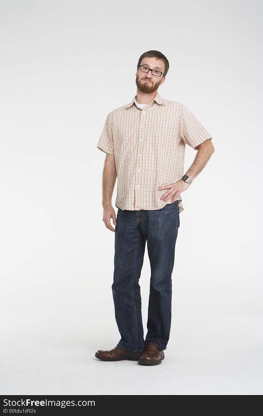 Man with beard and orange plaid shirt with denim jeans stands in a white photo studio. He is smiling and making a feminine gesture with on hand on his hip. Man with beard and orange plaid shirt with denim jeans stands in a white photo studio. He is smiling and making a feminine gesture with on hand on his hip.