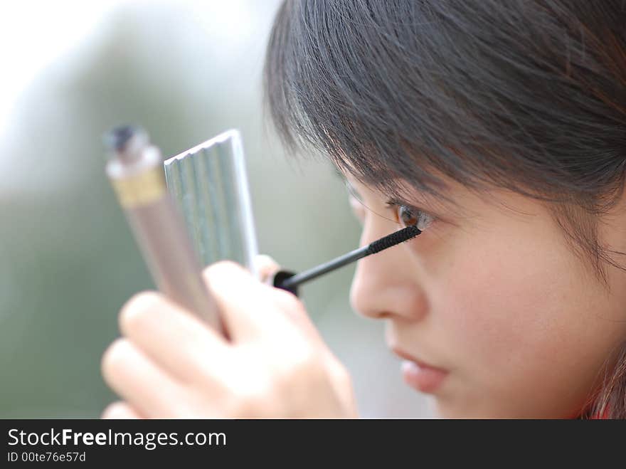 The girl is making up her eyes.