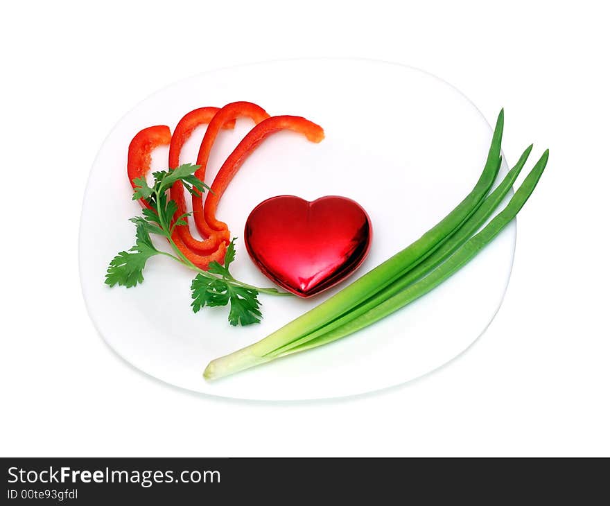 Toy heart on a plate isolated over a white background