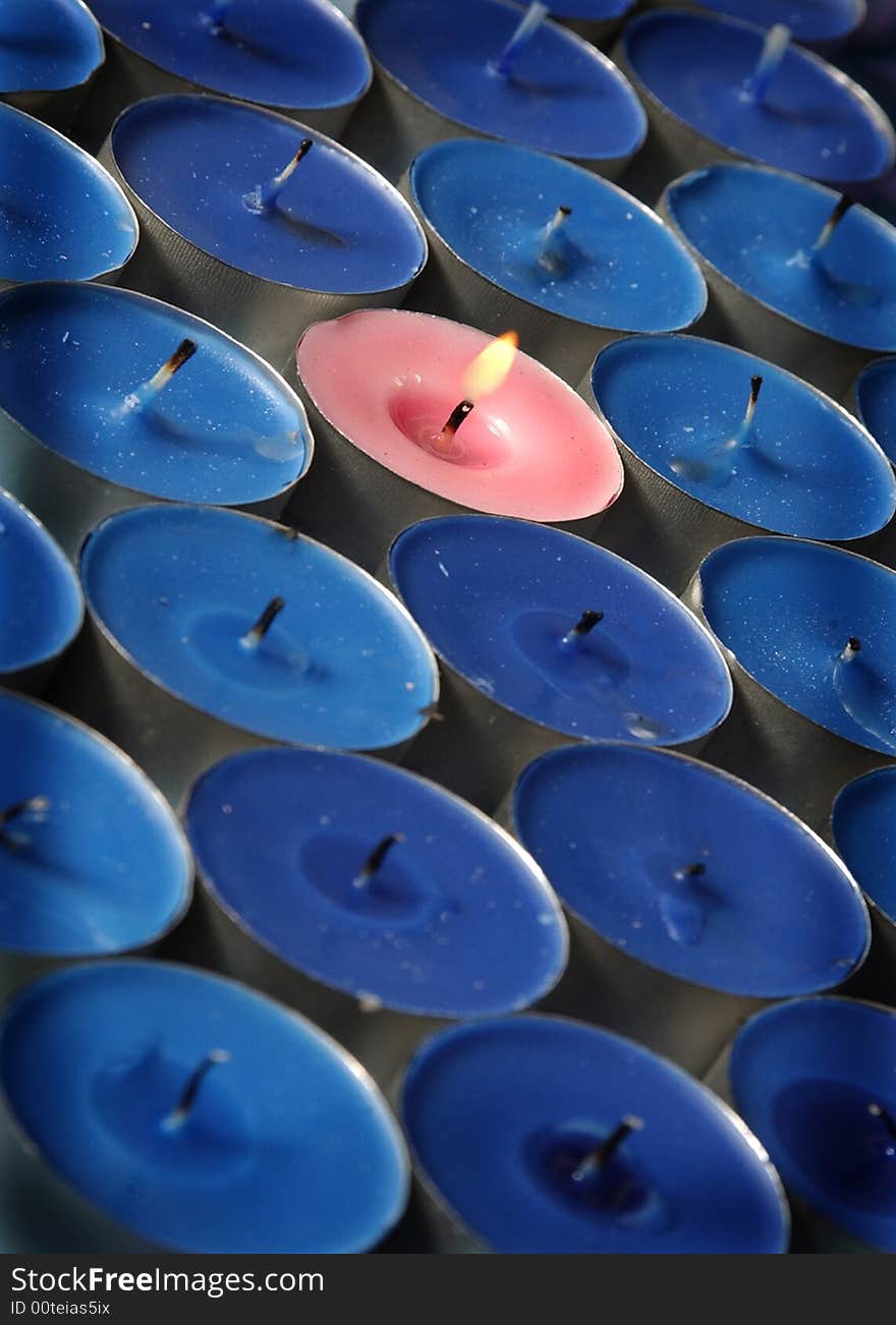 Pink candle surrounded by blue candles