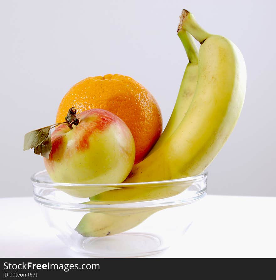 Banan apple and orange in the plate. Banan apple and orange in the plate