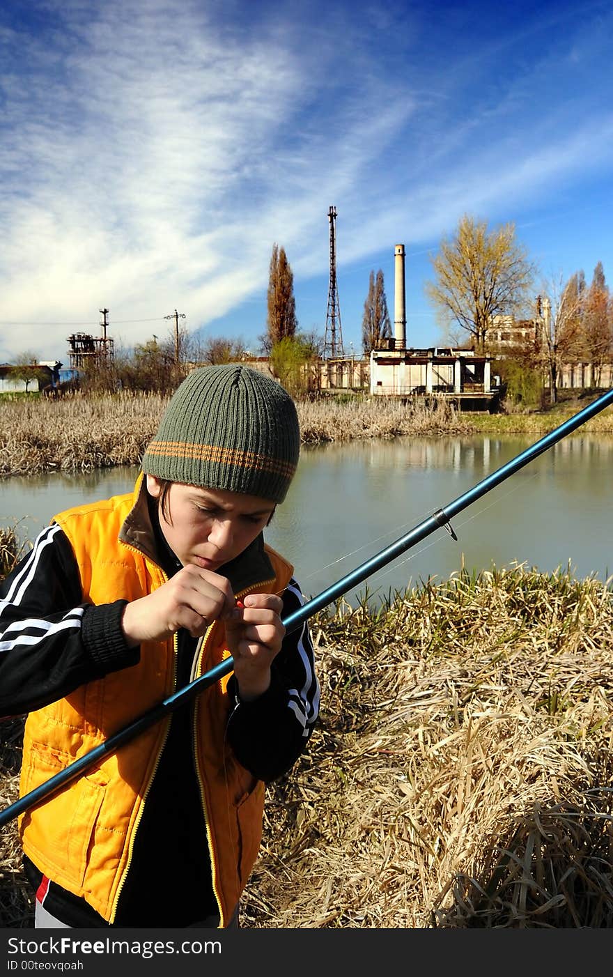 Little boy fishing in an industrial waste waters.