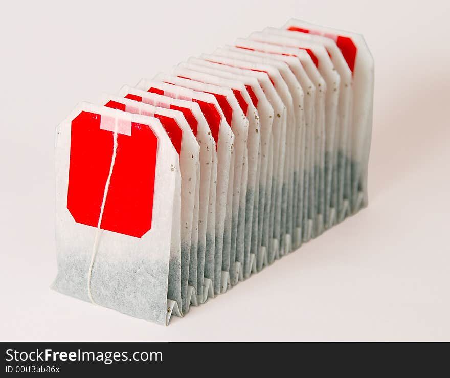 Tea bags pile stack with red labels isolated on white background. Tea bags pile stack with red labels isolated on white background