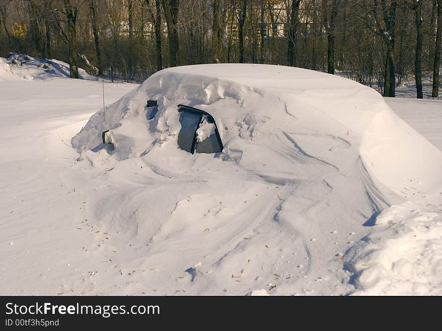 Car covered with snow in winter blizzard snowdrift