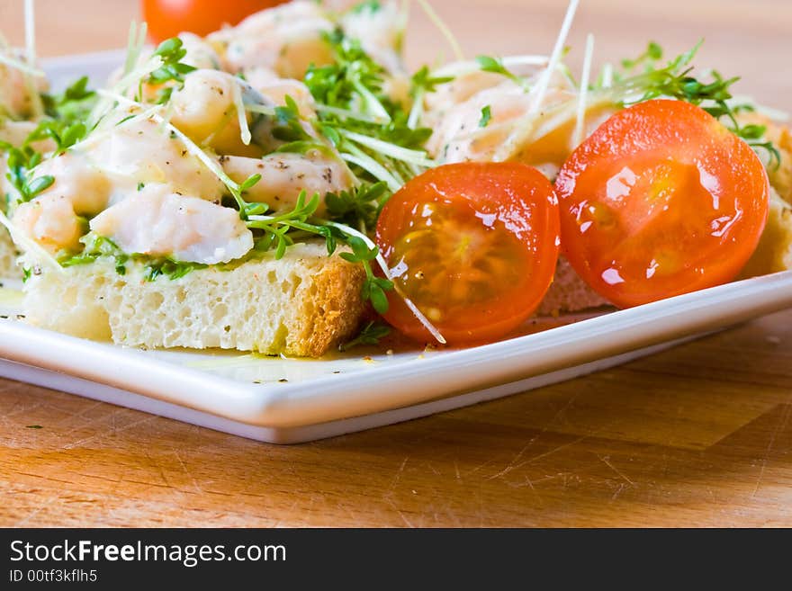 Prawn, cress and tomato sandwich on a white plate