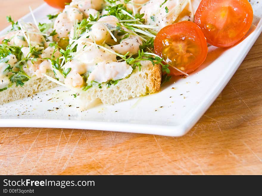 An open seafood sandwich with tomatoes