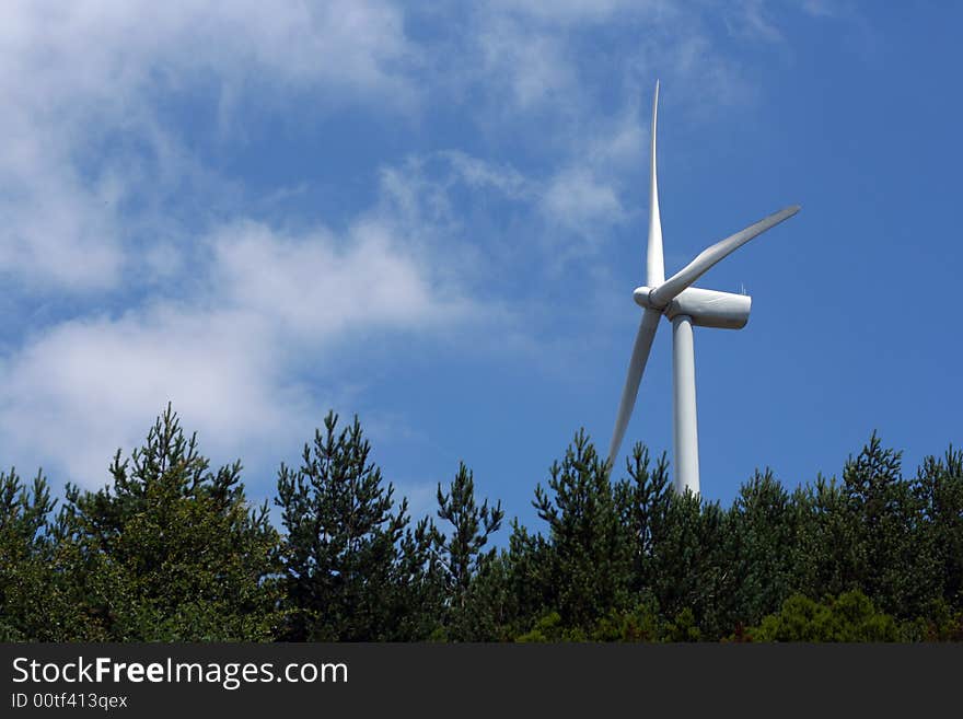 Wind power turbine under a blue sky.