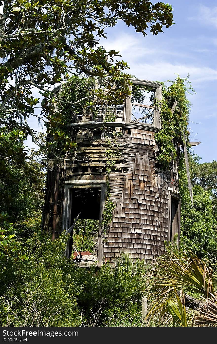 A round shingled tower on Cumberland Island,GA, is in a dilapidated condition. Foliage abounds as nature is reclaiming it. A round shingled tower on Cumberland Island,GA, is in a dilapidated condition. Foliage abounds as nature is reclaiming it.