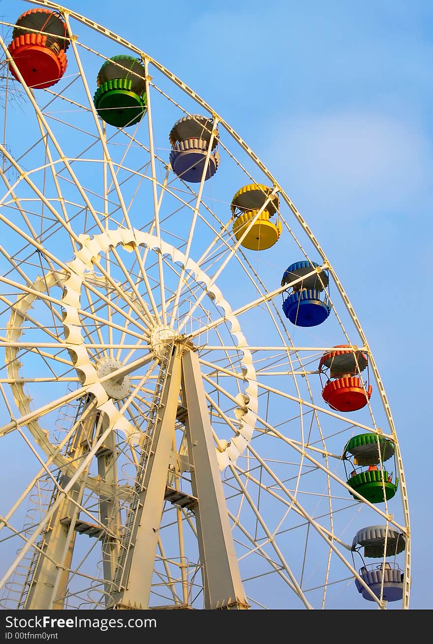 Big ferris wheel with colored cabins on cloudy sky. Big ferris wheel with colored cabins on cloudy sky