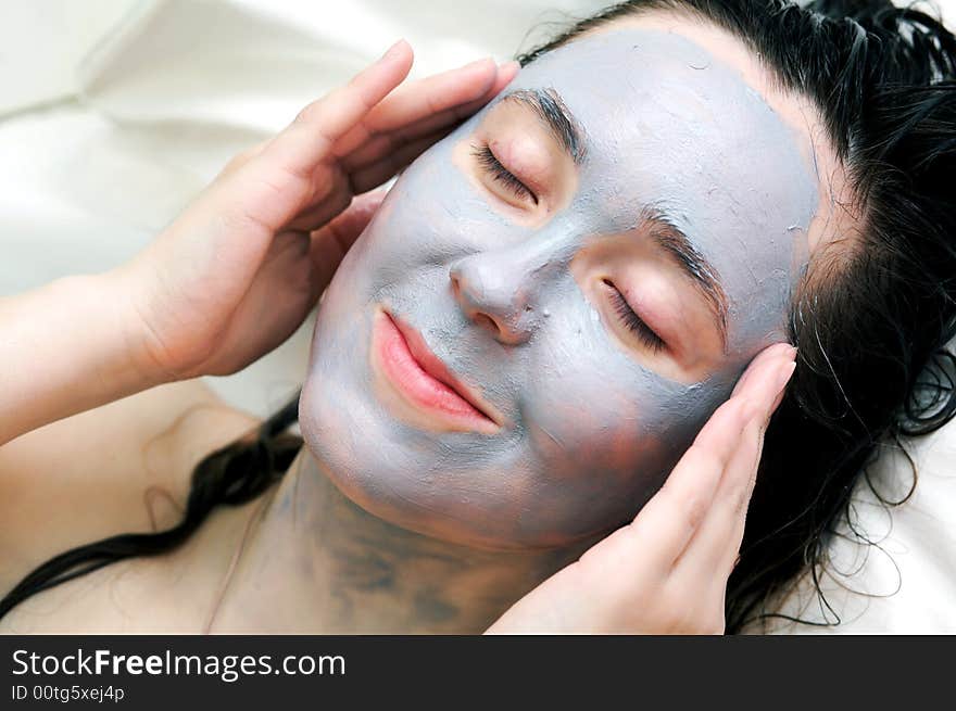 A woman putting a  mask on her face. A woman putting a  mask on her face