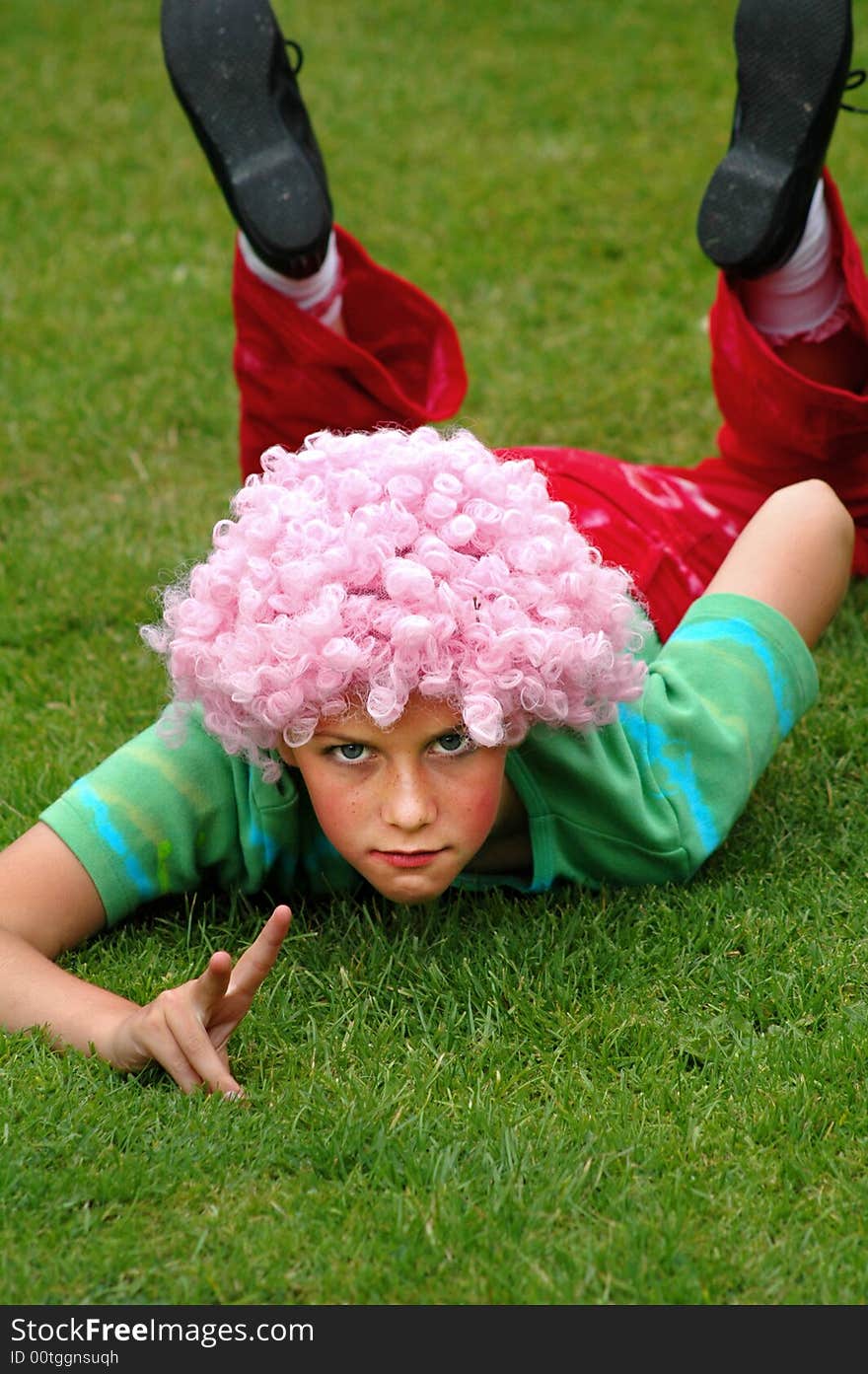 Natural portrait of girl lying in grass giving peace sign. Natural portrait of girl lying in grass giving peace sign