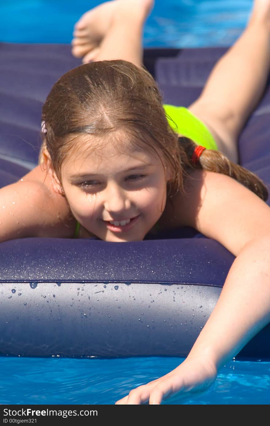 A girl-teenager bathes in a pool on dark blue. A girl-teenager bathes in a pool on dark blue