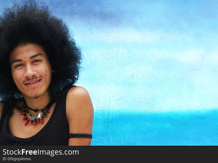 Thai man with a big afro hairstyle and fang teeth.