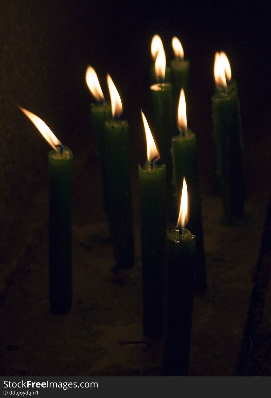 Burning green candles on black background. Burning green candles on black background