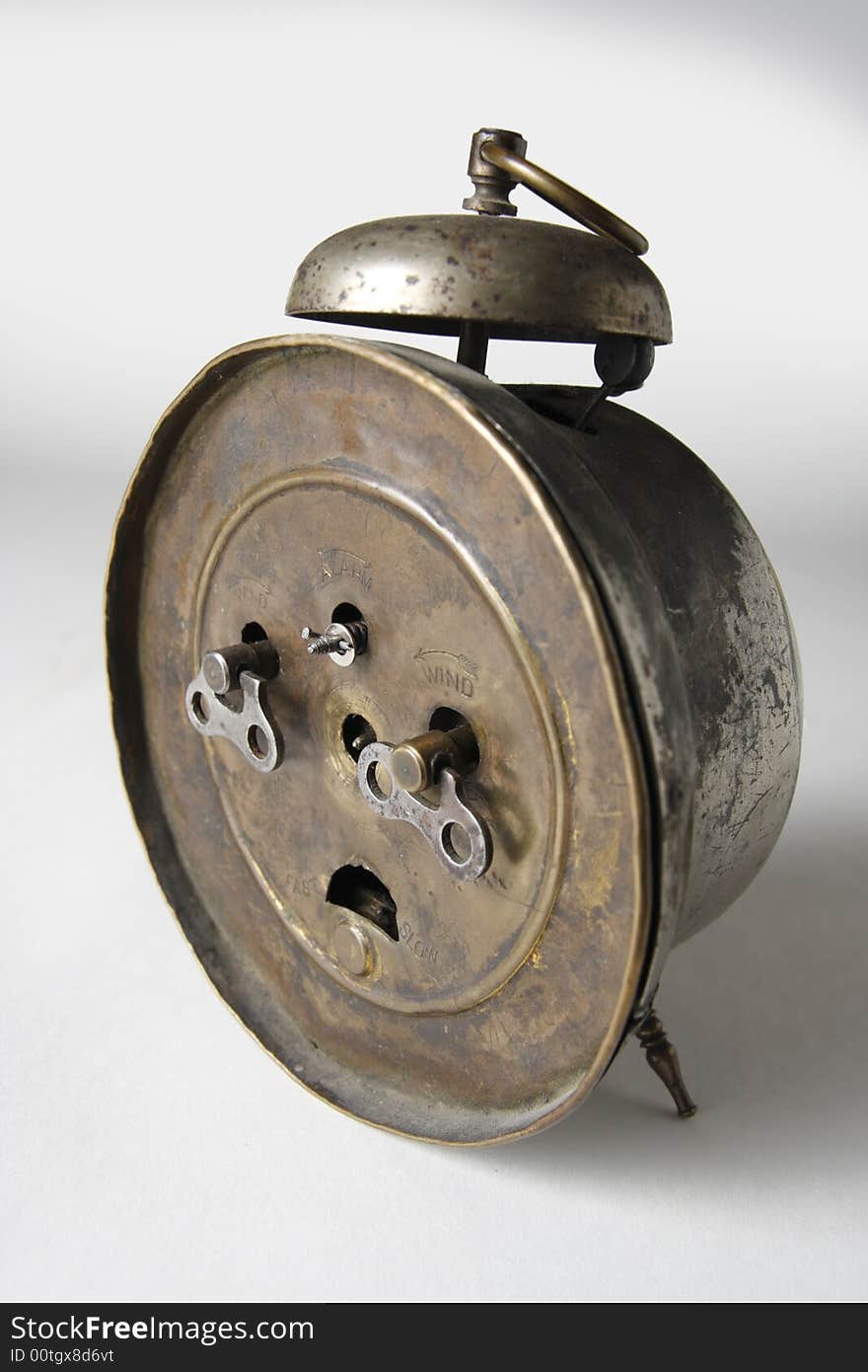 The backside of an old alarm-clock. Clockwork keys. The backside of an old alarm-clock. Clockwork keys.