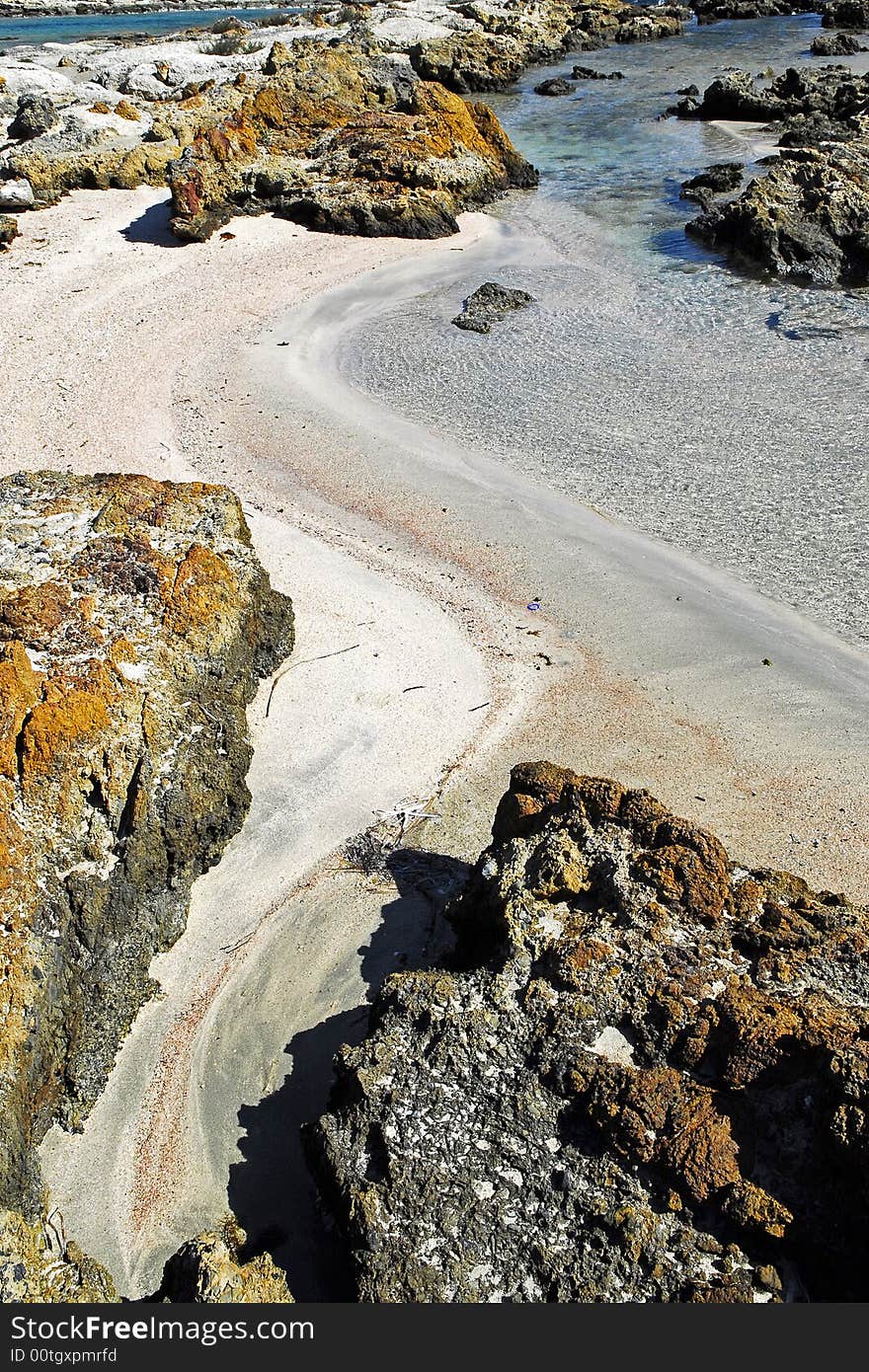 Pink sand between the rocks in elafonisi