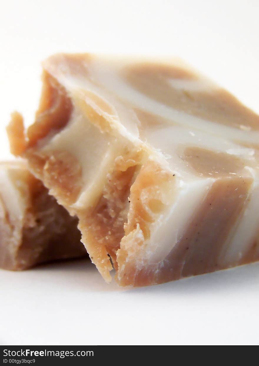 Image of a bar of handmade, handcut cinnamon soap broken into two pieces, one leaning against the other. White background and vertical orientation. Image of a bar of handmade, handcut cinnamon soap broken into two pieces, one leaning against the other. White background and vertical orientation.